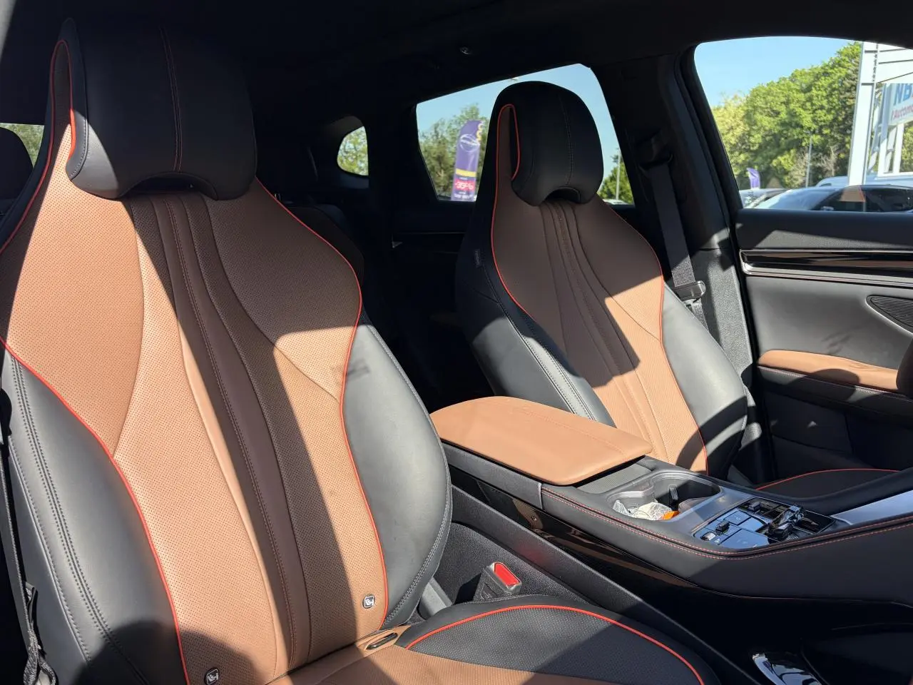 Vue intérieure des sièges avant en similicuir noir et brun avec surpiqûres rouges du BYD SEAL U 2025.