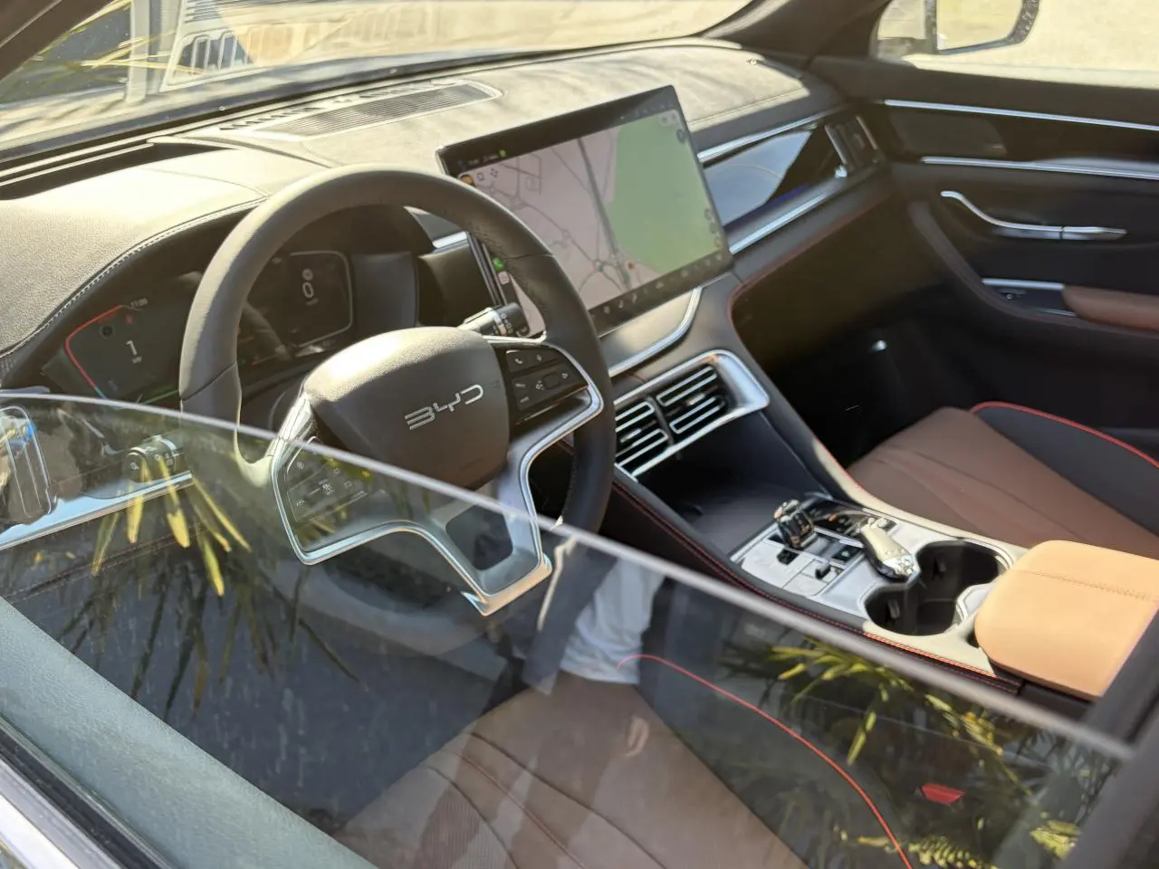 Vue intérieure côté conducteur du BYD SEAL U 2025 avec habitacle noir et brun, écran tactile central et volant multifonction.