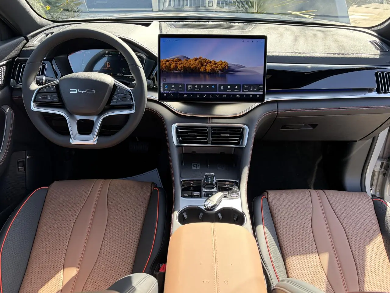 Vue intérieure avant du BYD SEAL U 2025 avec tableau de bord noir et brun, écran tactile 15,6 pouces et volant multifonction.