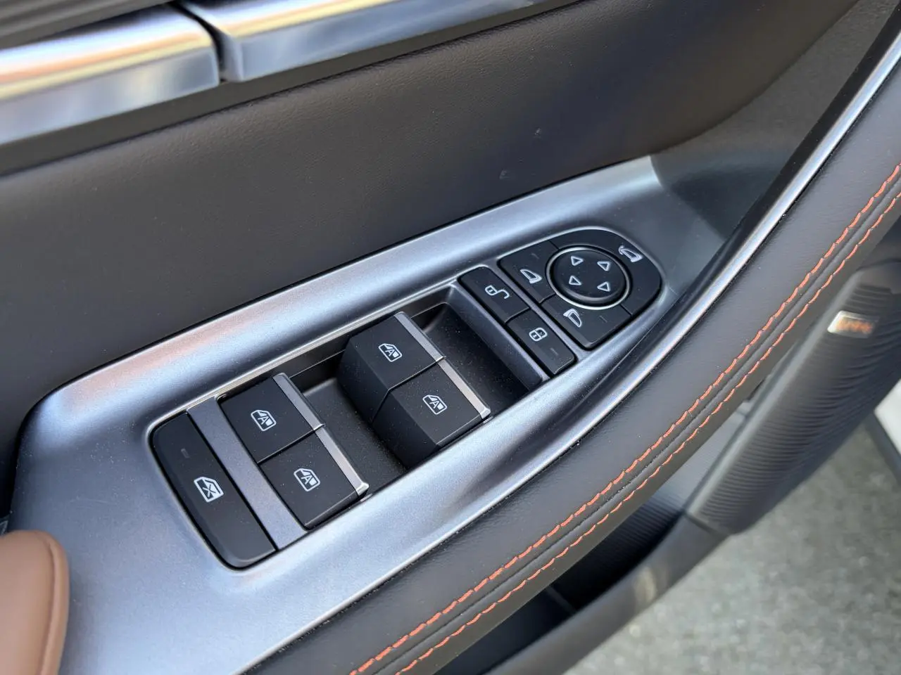 Gros plan sur les commandes des vitres et rétroviseurs côté conducteur du BYD SEAL U 2025 en intérieur noir et brun.