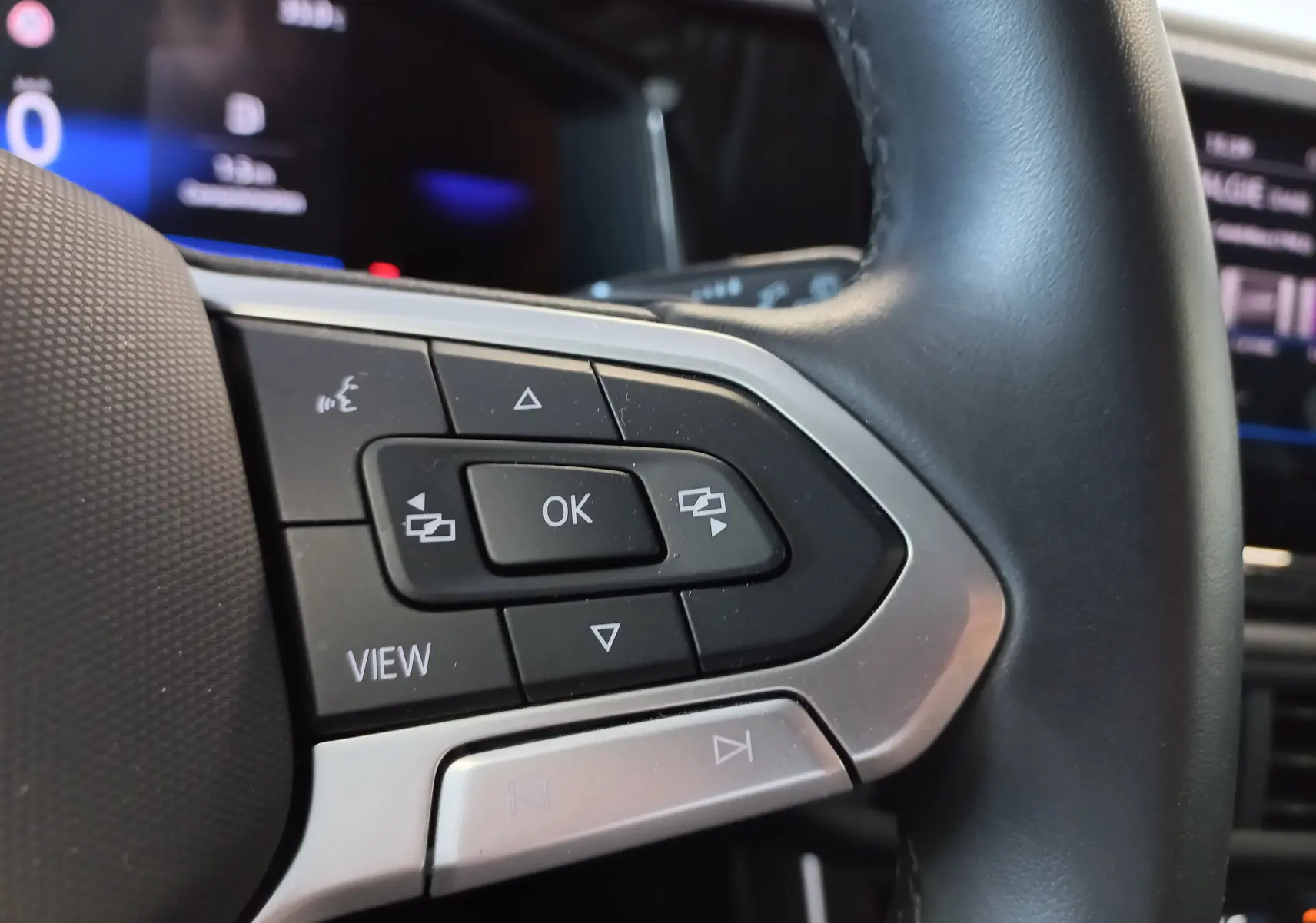Gros plan sur les commandes multifonctions à gauche du volant du Volkswagen Taigo 2025, finition VW Edition ++.