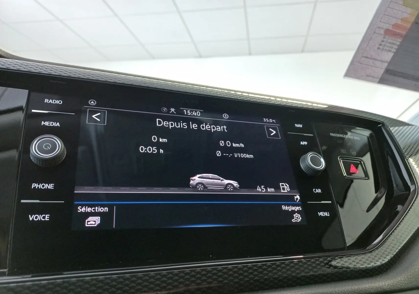 Écran tactile central affichant l'interface de bord du Volkswagen Taigo 2025 avec détails de trajet et commandes autour.