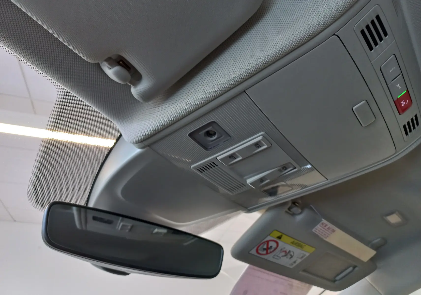 Vue intérieure du plafond et rétroviseur d’un Volkswagen Taigo 2025, avec pare-soleil et commandes lumineuses grises.