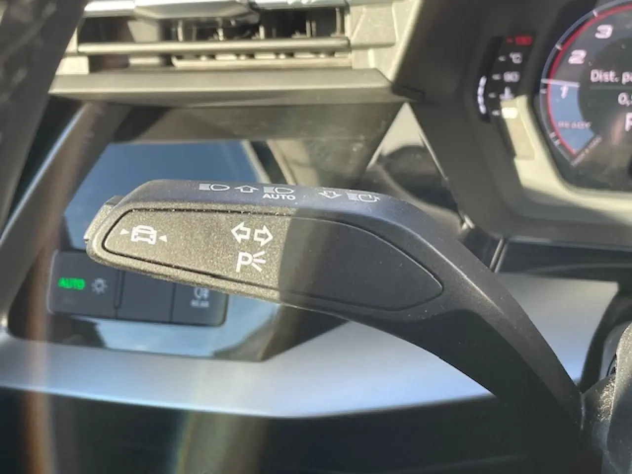 Gros plan sur la commande de clignotant et d'aide au stationnement dans l'Audi A3 argent fleuret 2022.