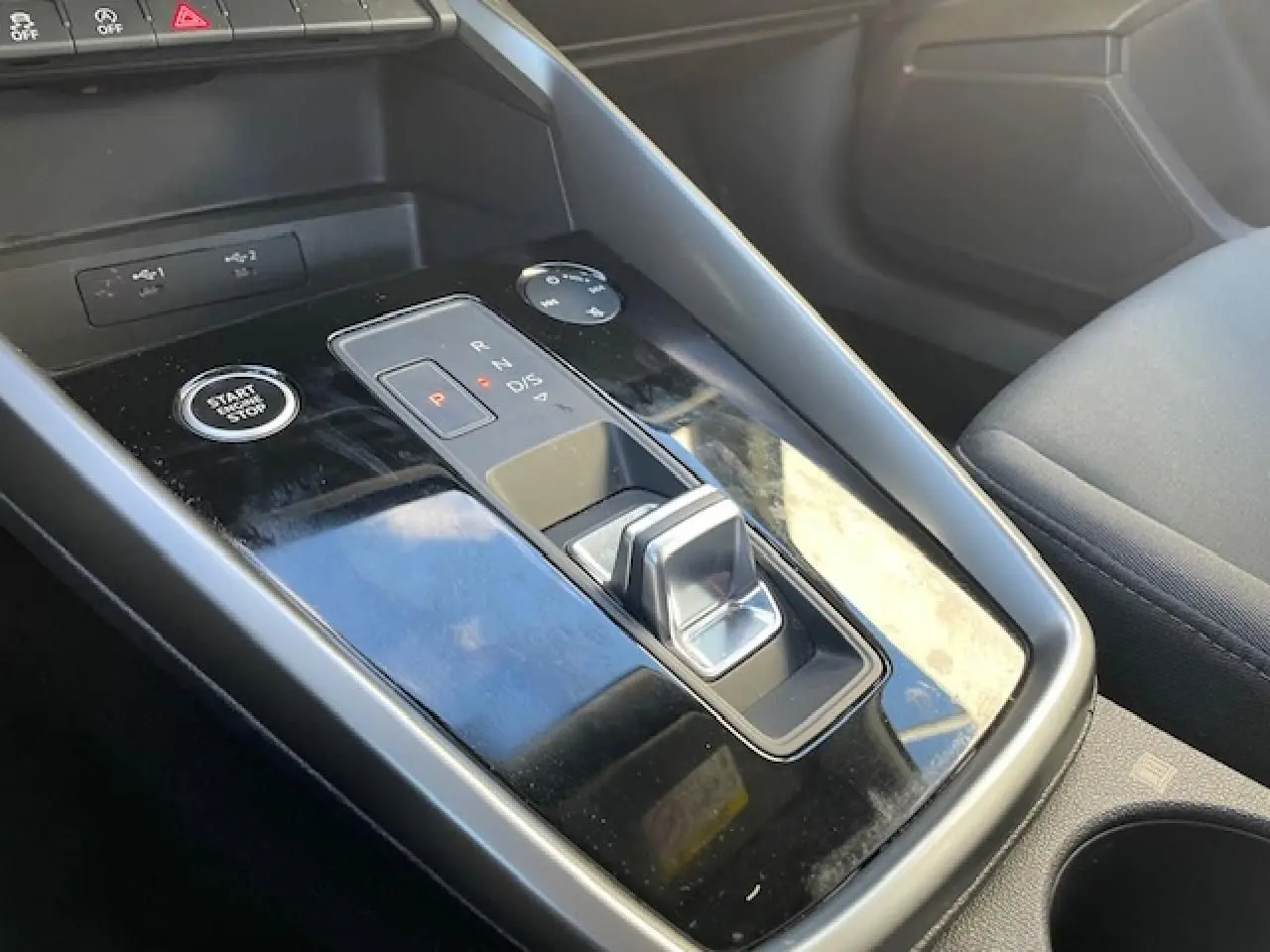 Gros plan sur la console centrale noire brillante avec levier de vitesses et bouton start/stop de l'Audi A3 argent fleuret 2022