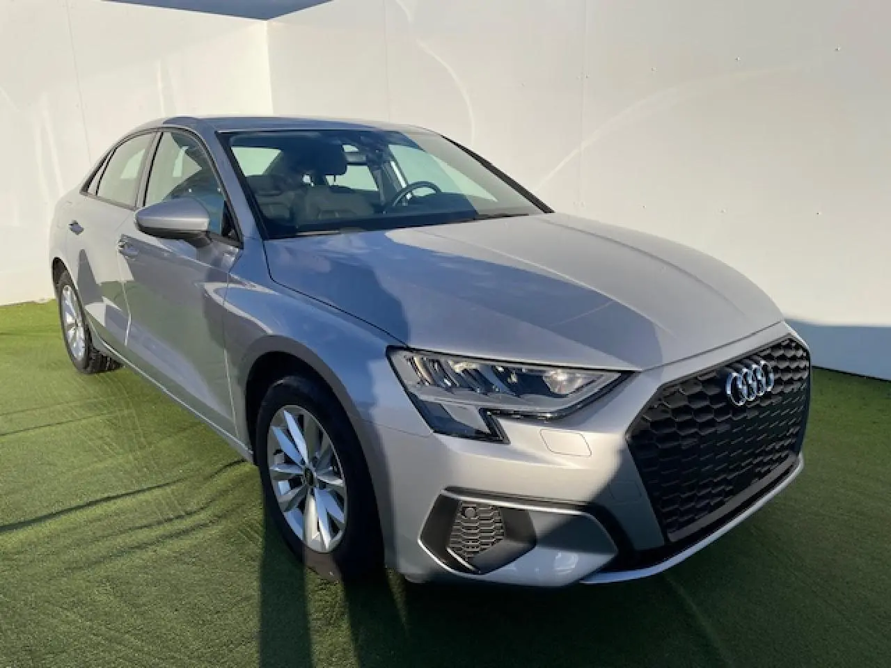 Audi A3 IV Berline argent métallisé vue 3/4 avant droit, avec calandre noire et phares LED distinctifs.