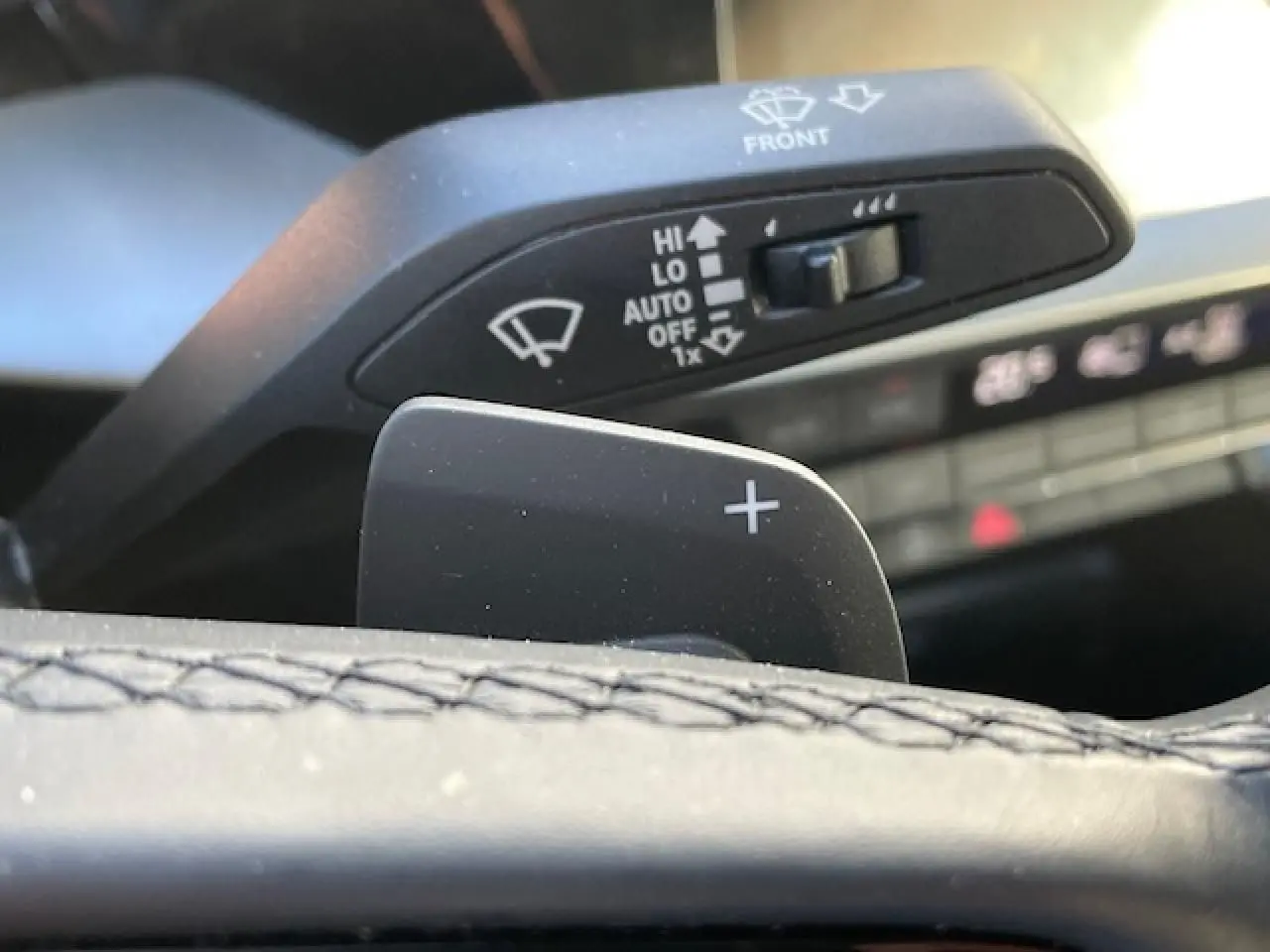 Gros plan sur la palette de changement de vitesses droite en cuir noir de l'Audi A3 2022, avec commandes d'essuie-glace en arrière-plan.