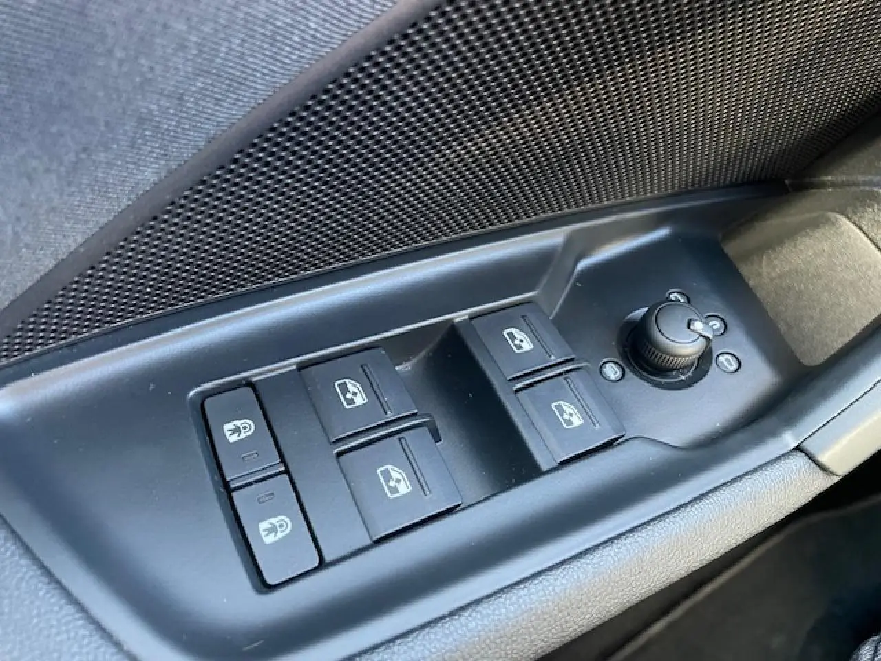 Gros plan sur les commandes des vitres et rétroviseurs côté conducteur de l'Audi A3 IV Berline argent métallisé.