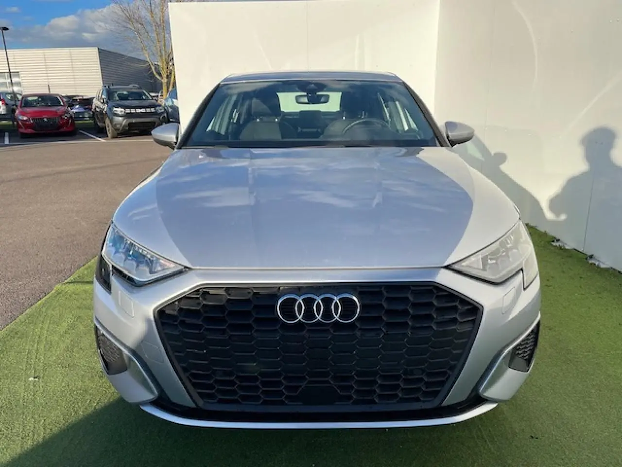 Vue frontale d'une Audi A3 berline 2022 argent métallisé avec calandre noire hexagonale et phares LED distinctifs.