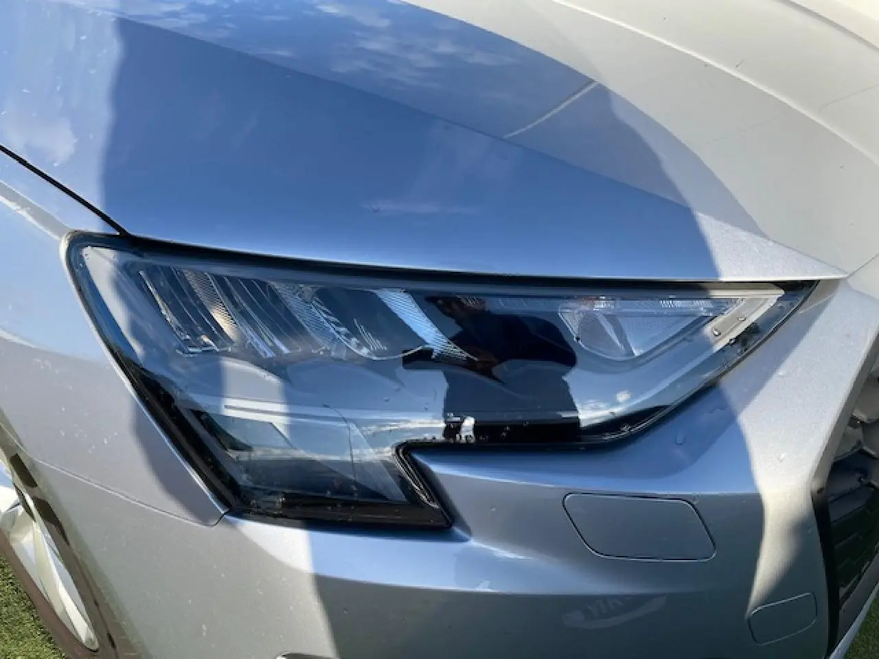 Gros plan sur le phare avant droit argenté de l'Audi A3 IV Berline 30 TFSI MHEV 2022 avec peinture métallisée.