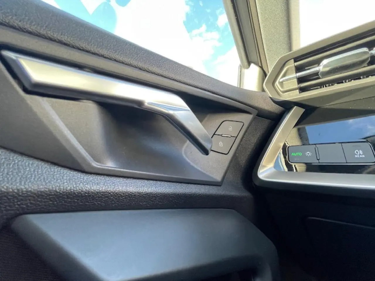 Poignée de porte côté gauche et commandes d’éclairage intérieur de l’Audi A3 IV Berline 2022, finition argent métallisé.