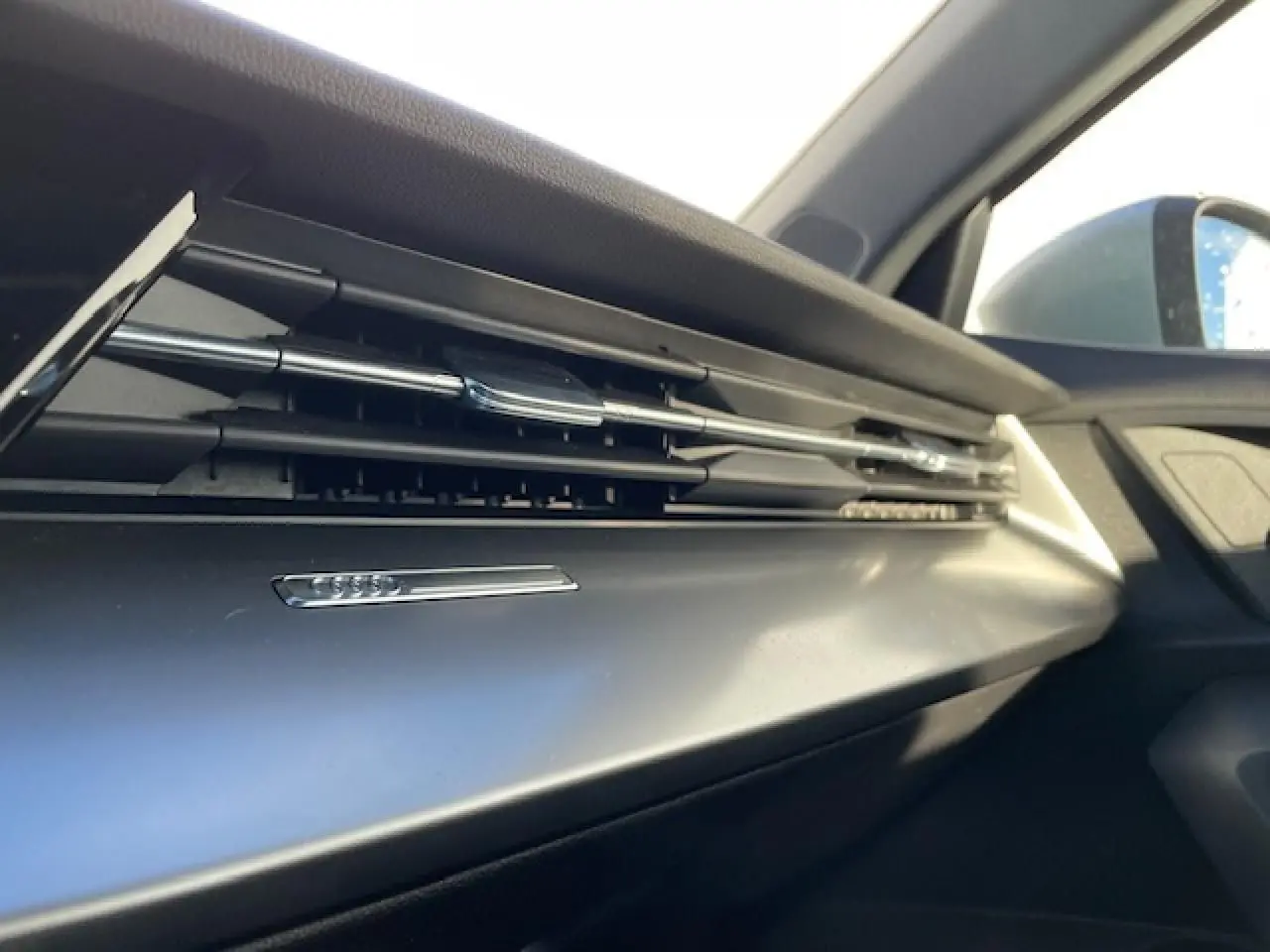 Détail de la sortie d'air chromée côté passager de l'habitacle de l'Audi A3 IV Berline argent métallisé 2022.