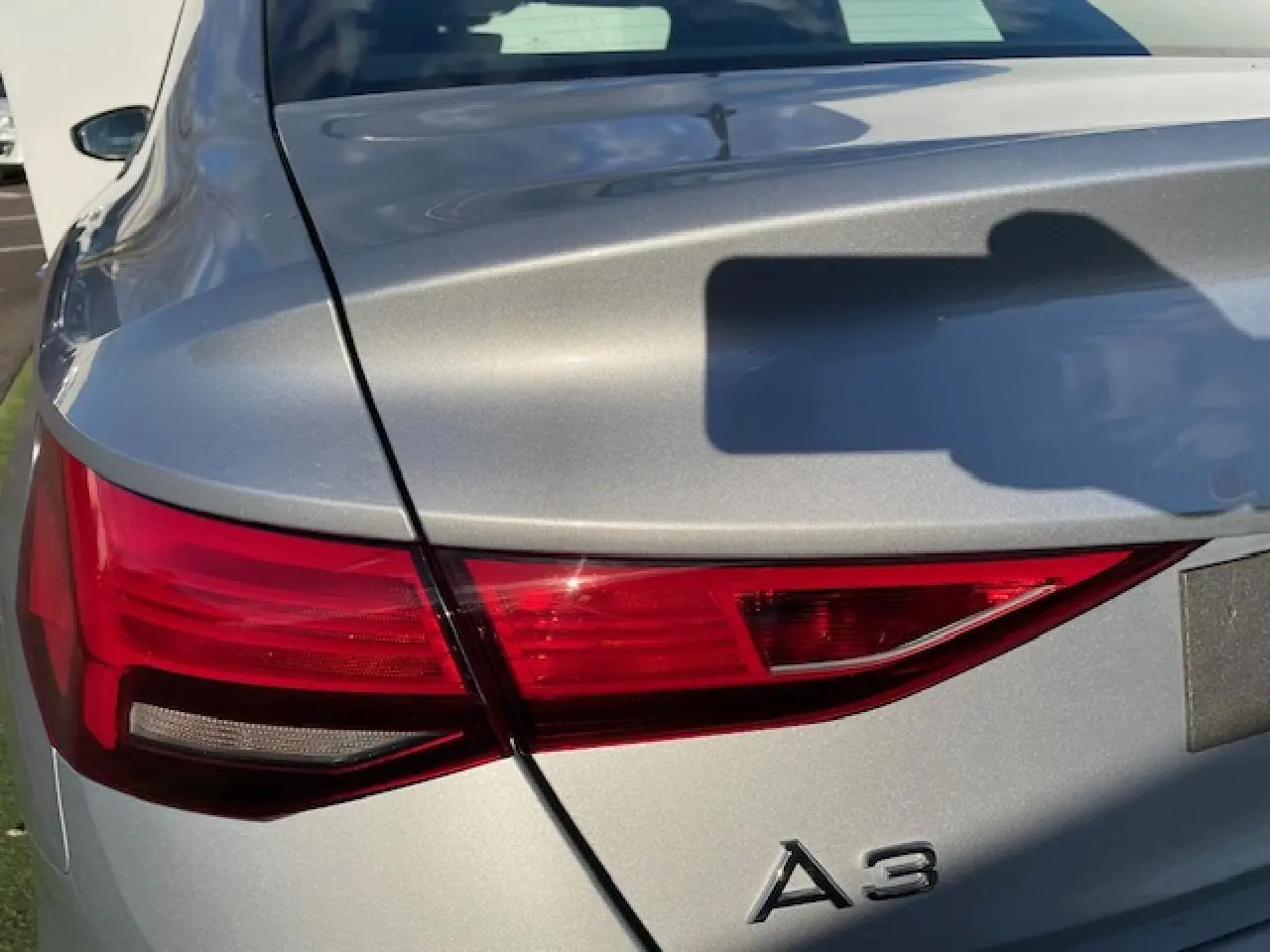Gros plan sur le feu arrière gauche argenté métallisé d'une Audi A3 IV Berline 2022, soulignant ses lignes nettes.