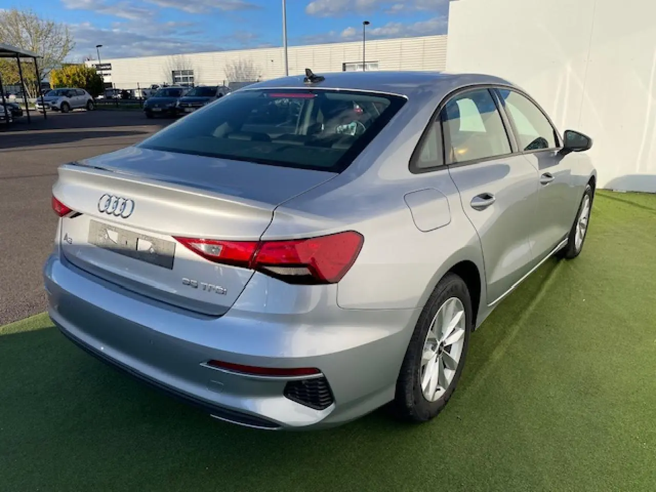 Audi A3 IV Berline argent métallisé vue 3/4 arrière droit, avec feux LED et jantes alliage 17 pouces.