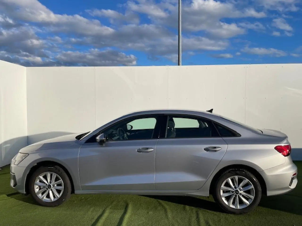 Profil côté gauche d'une Audi A3 berline 2022 argent métallisé, avec jantes alliage et lignes épurées.