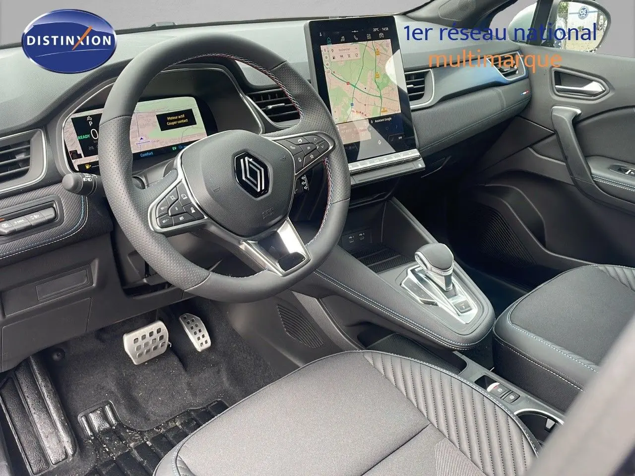 Intérieur avant du Renault Captur E-Tech hybride 2025, volant multifonction et écran tactile central visible.