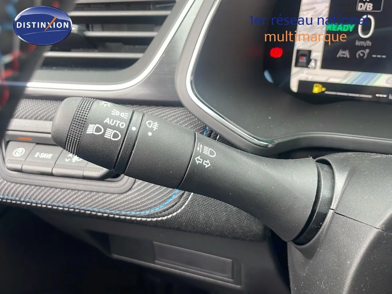 Gros plan sur la commande des phares et clignotants du tableau de bord du Renault Captur E-Tech hybride 2025.