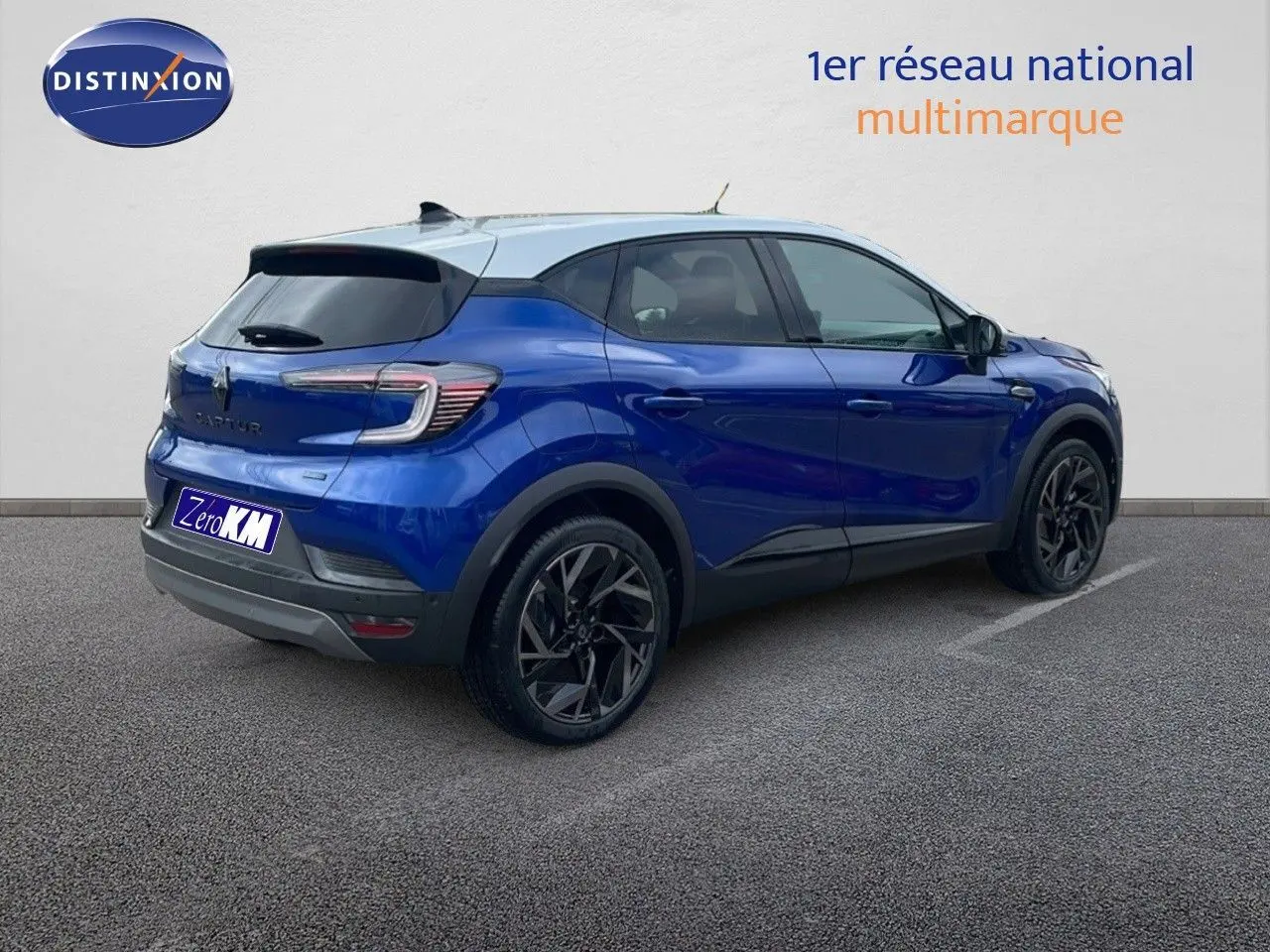 Renault Captur E-Tech hybride bleu Iron Metal avec toit gris, vu de trois quarts arrière côté droit.