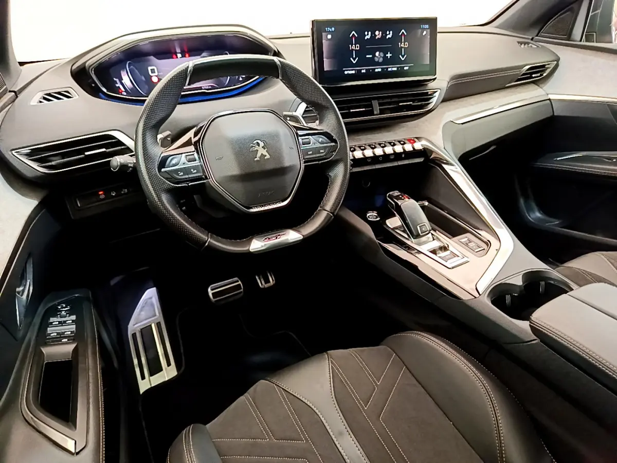 Intérieur du Peugeot 3008 GT 2021, vue côté conducteur sur volant cuir, tableau de bord digital et console centrale moderne.