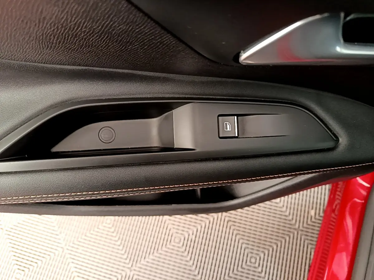 Poignée intérieure côté gauche avec bouton de verrouillage sur porte rouge du Peugeot 3008 GT 2021.