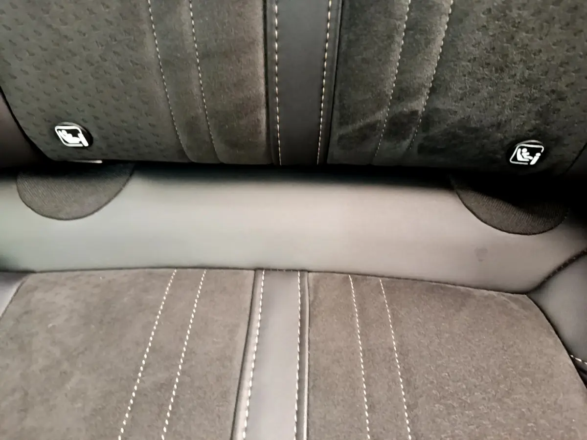 Gros plan sur la banquette arrière en tissu gris avec surpiqûres contrastantes et fixations Isofix visibles.