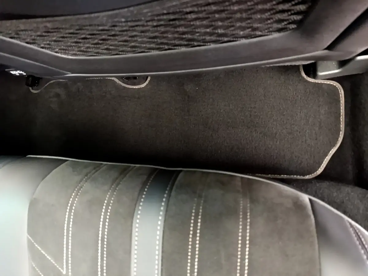 Vue rapprochée du tapis de sol et de la partie inférieure du siège avant côté droit dans un Peugeot 3008 GT rouge.