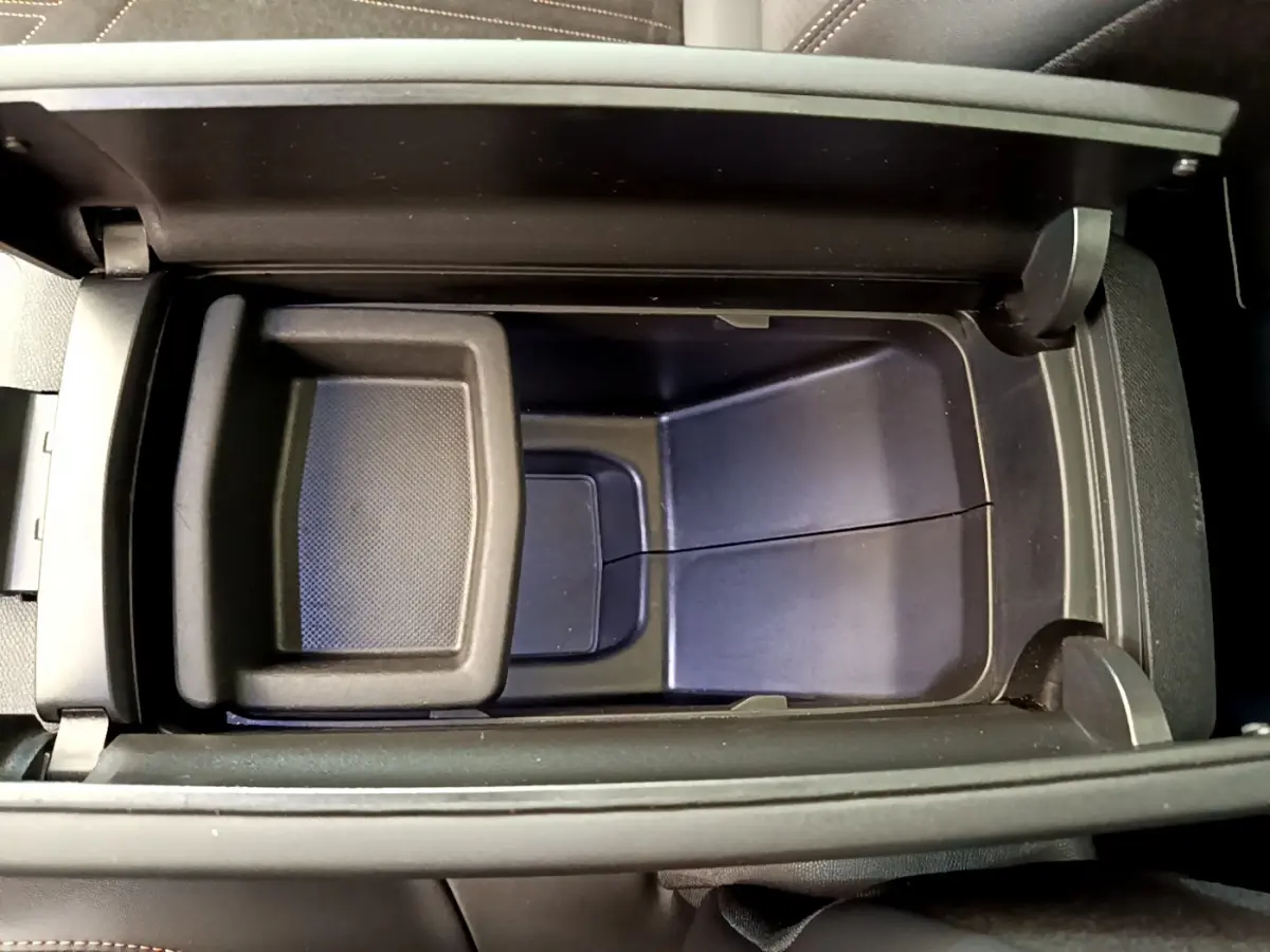 Vue plongeante sur le rangement central noir du Peugeot 3008 GT 2021, mettant en valeur son espace intérieur fonctionnel.