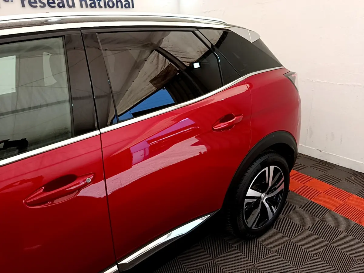 Vue côté droit arrière du Peugeot 3008 GT rouge avec jante alliage et contour de vitre chromé.