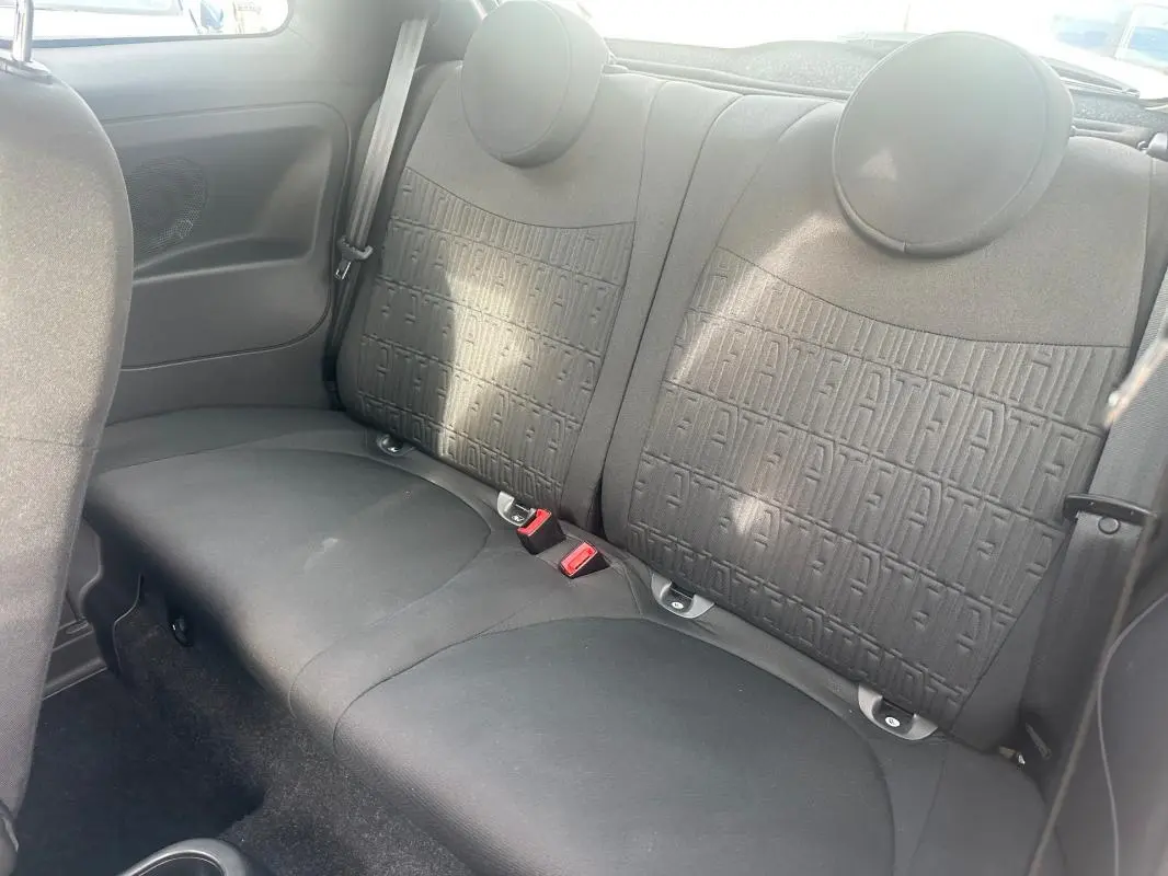 Vue intérieure sur les sièges arrière noirs de la FIAT 500 2023 avec motifs FIAT embossés sur le dossier.