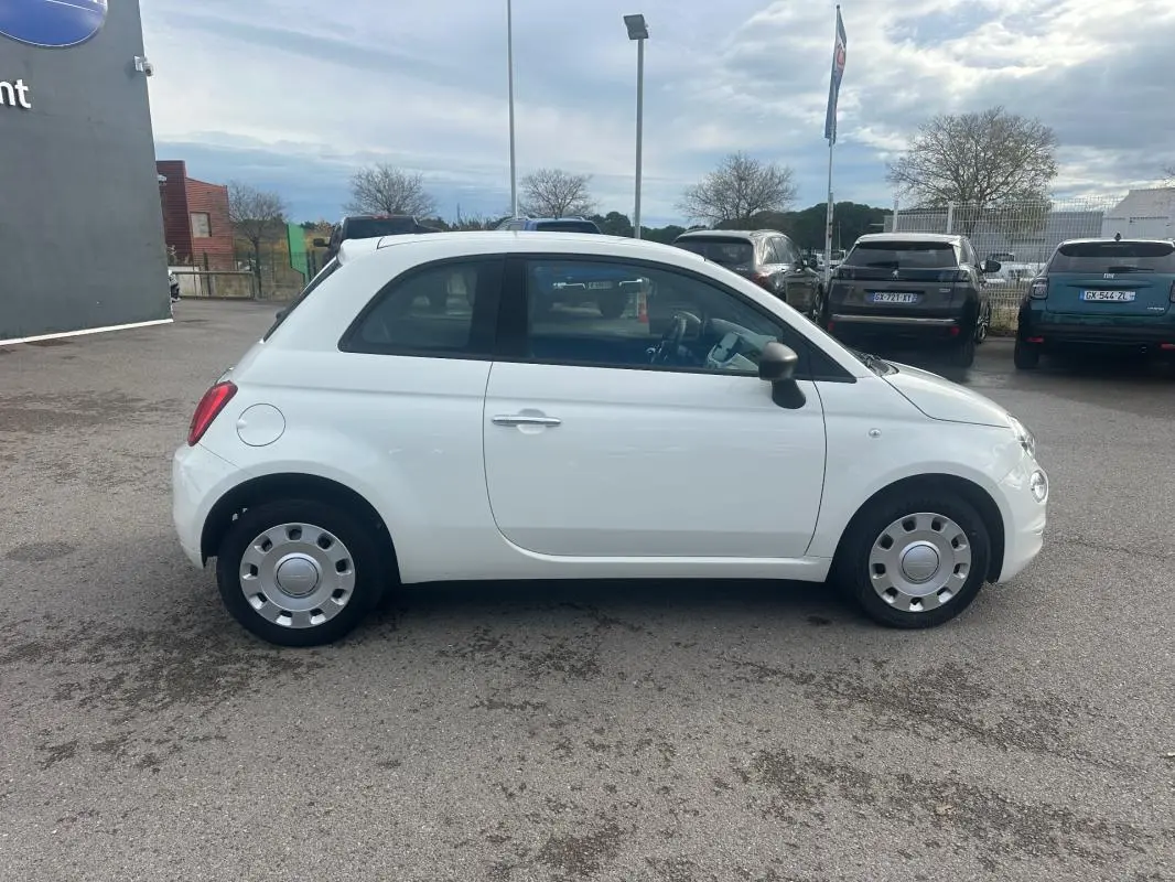 Vue de profil côté gauche d'une FIAT 500 blanche de 2023, compacte avec jantes acier et rétroviseurs noirs.