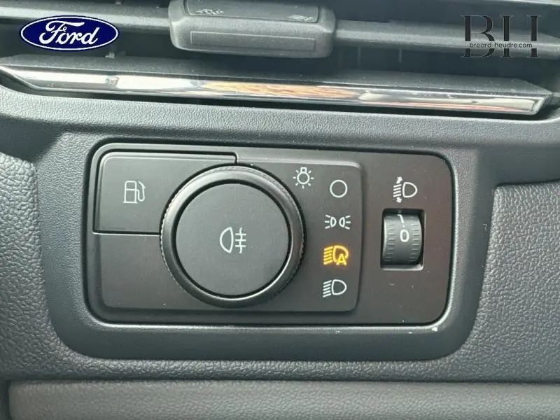 Gros plan sur le panneau de commande des phares du Ford Transit Custom gris lunaire, avec éclairage automatique activé.