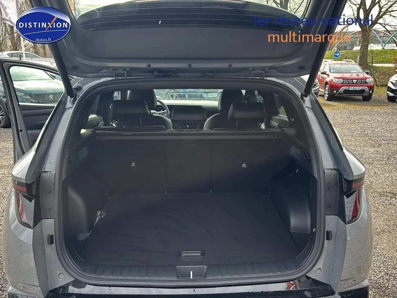 Vue arrière du Hyundai Tucson 2026 gris shadow avec coffre ouvert et intérieur spacieux visible.