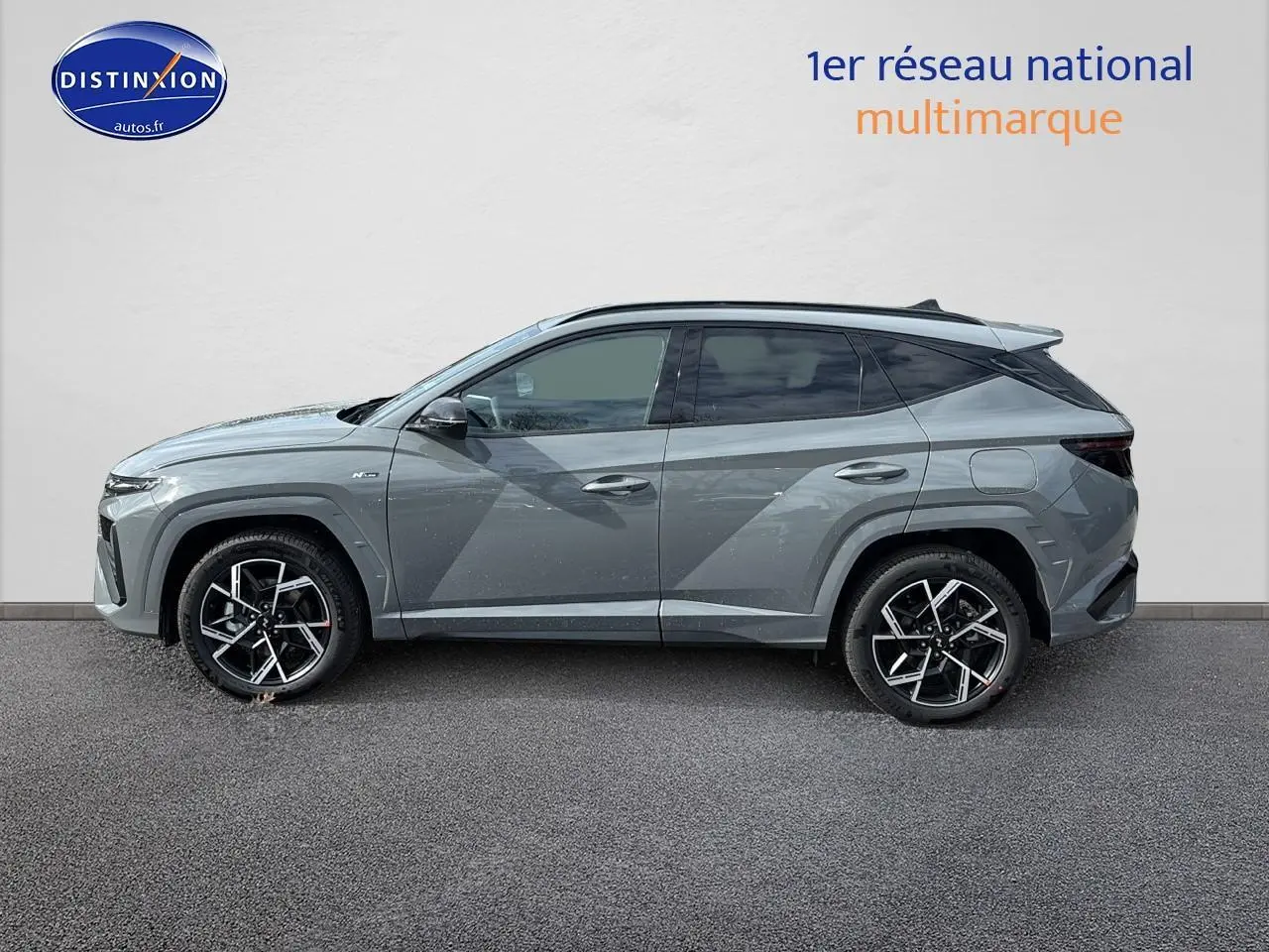 Vue de profil côté gauche du Hyundai Tucson 2026 gris shadow avec jantes alliage 19 pouces et vitres surteintées.