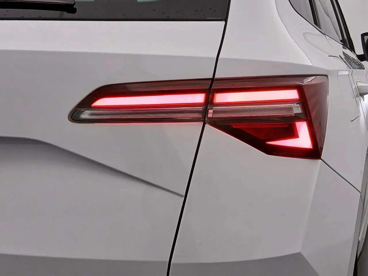 Gros plan sur le feu arrière droit allumé du Skoda Karoq blanc lune 2025 version Sportline.