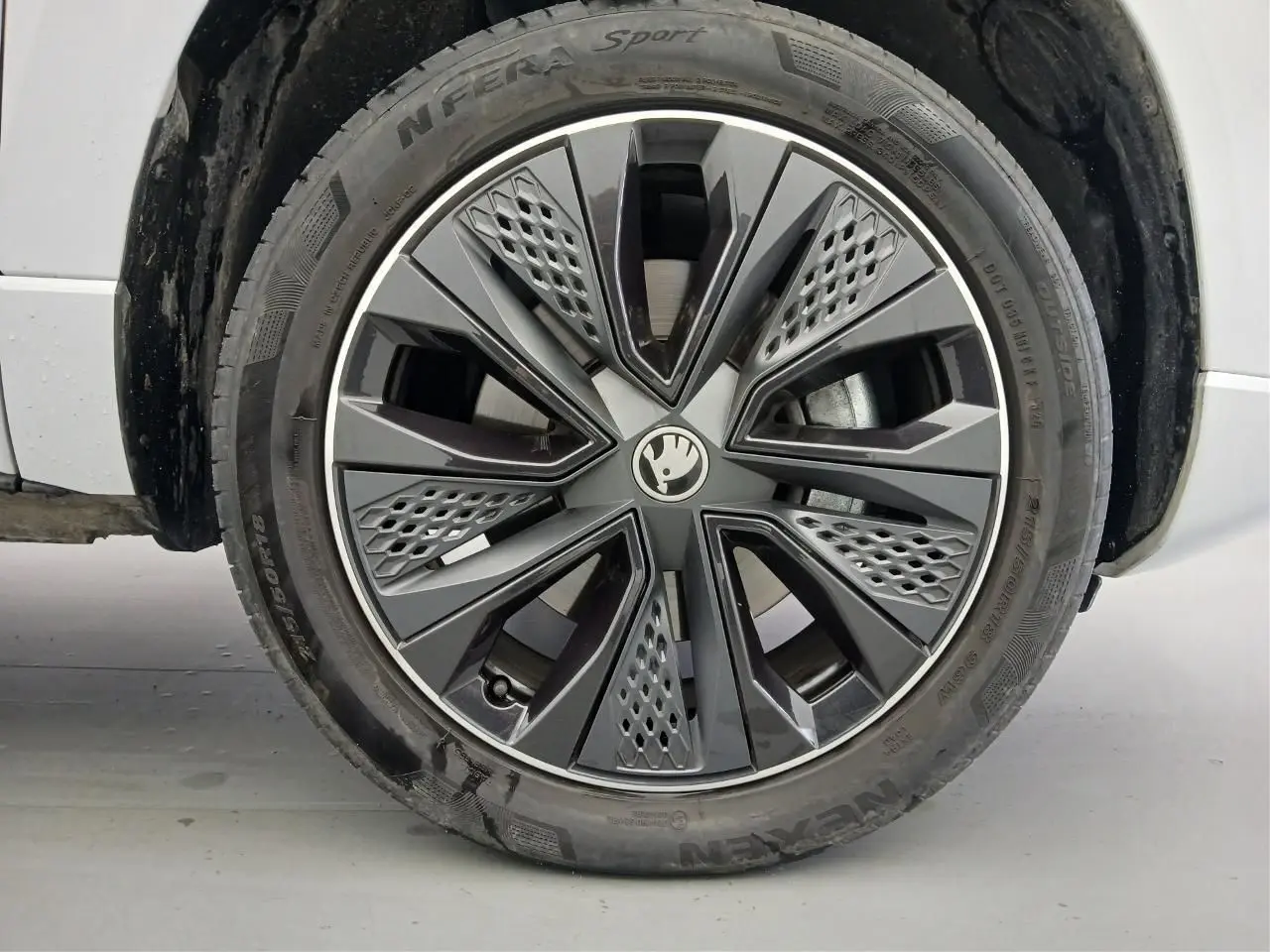 Gros plan sur la roue avant droite du Skoda Karoq Blanc Lune 2025 avec jante alliage Sportline au design moderne.