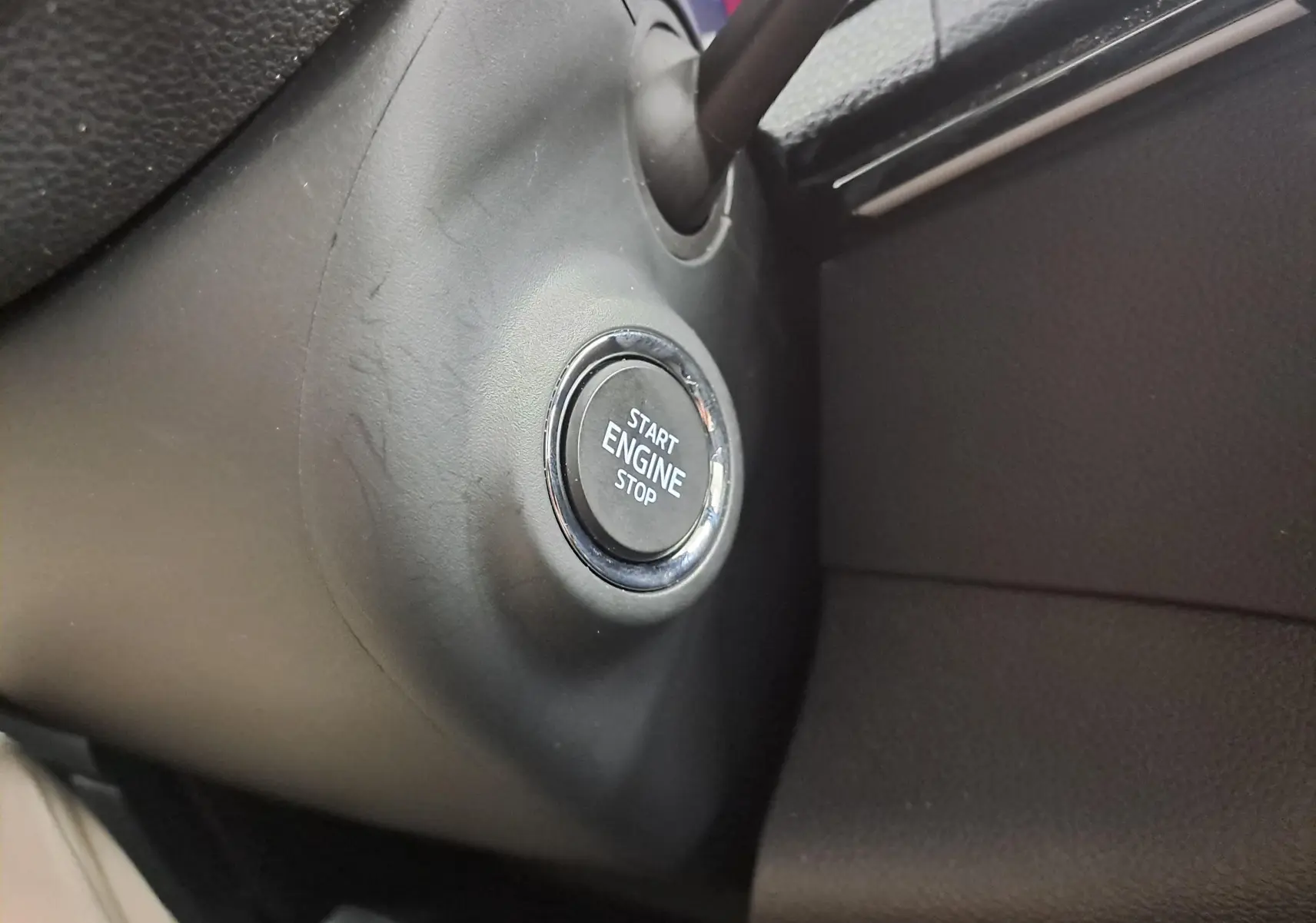 Gros plan sur le bouton Start Engine Stop du tableau de bord intérieur du Skoda Karoq 1.5 TSI 150 DSG7 Sportline blanc lune 2025.