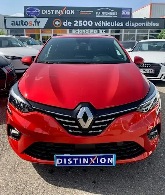 Vue frontale d'une Renault Clio V rouge 2021 avec calandre noire et logo Renault proéminent.