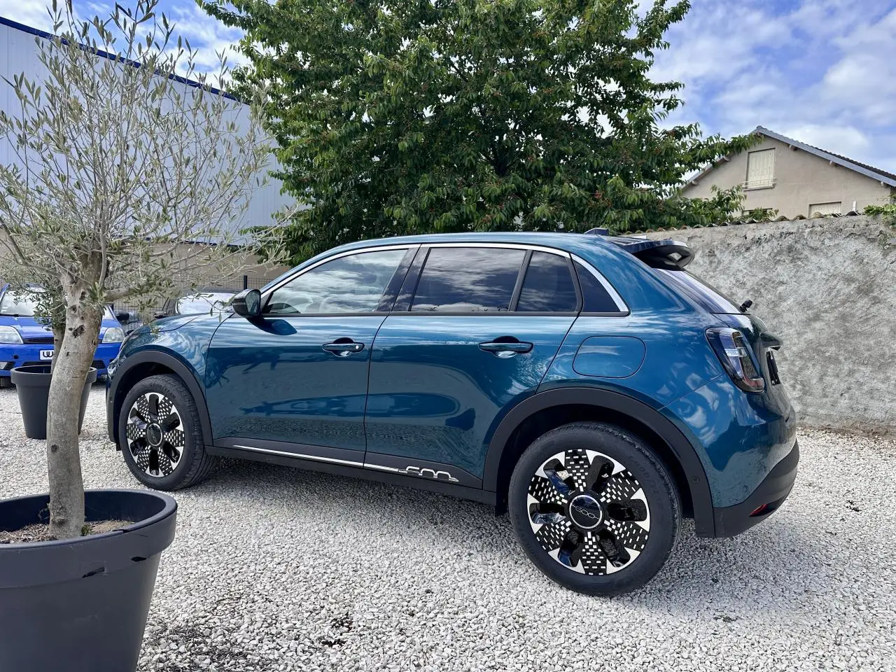 Vue latérale droite d'une FIAT 600 1.2 Hybrid bleu clair avec jantes stylisées et vitres surteintées.