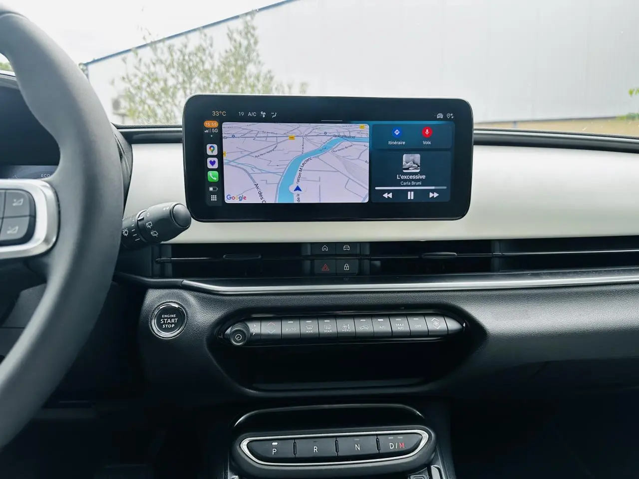 Vue intérieure du tableau de bord ivoire du Fiat 600 La Prima 2024 avec écran tactile central et commandes climatisation.