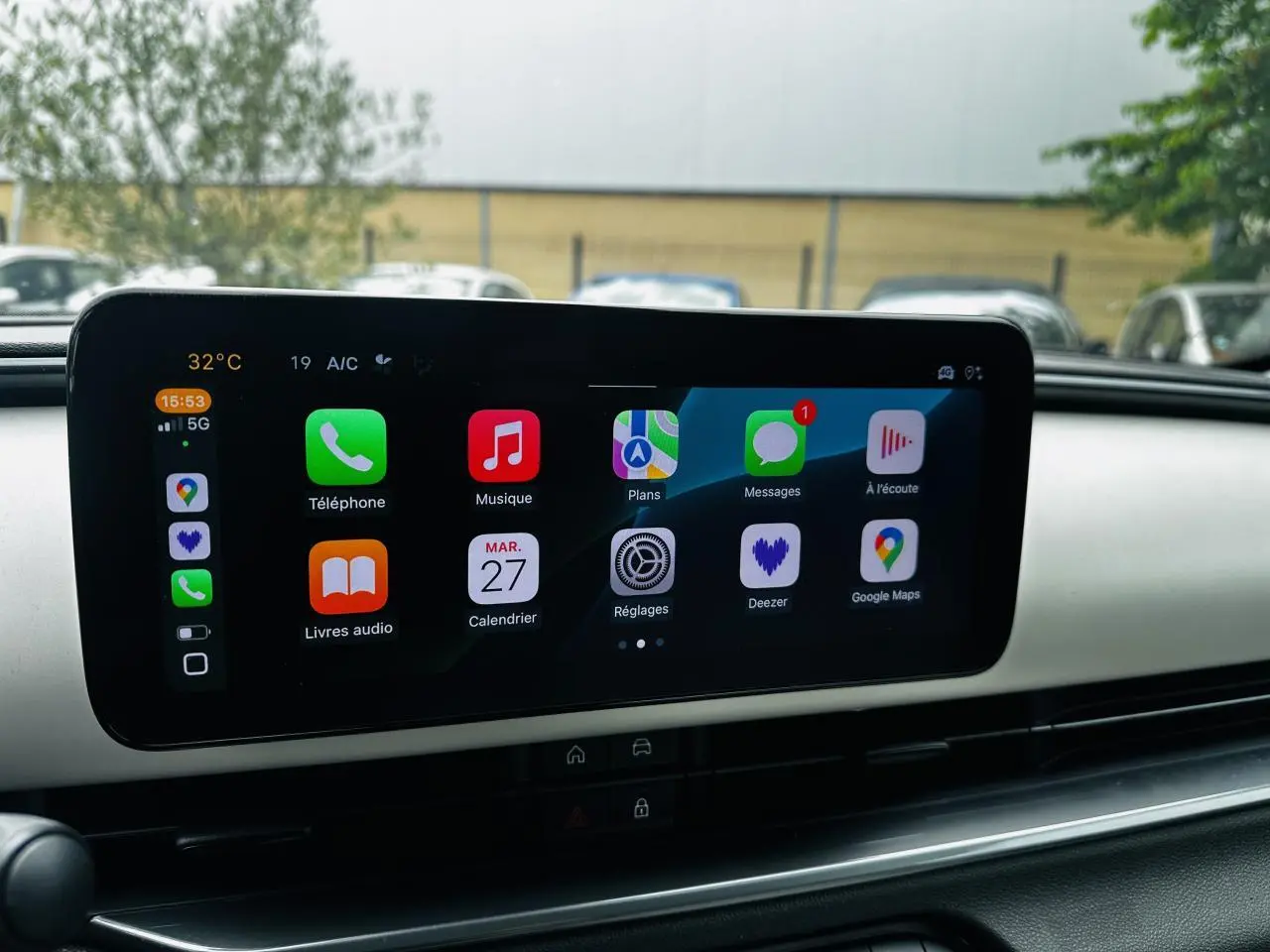 Écran tactile central affichant Apple CarPlay dans l'habitacle du FIAT 600 bleu clair, vue de face.