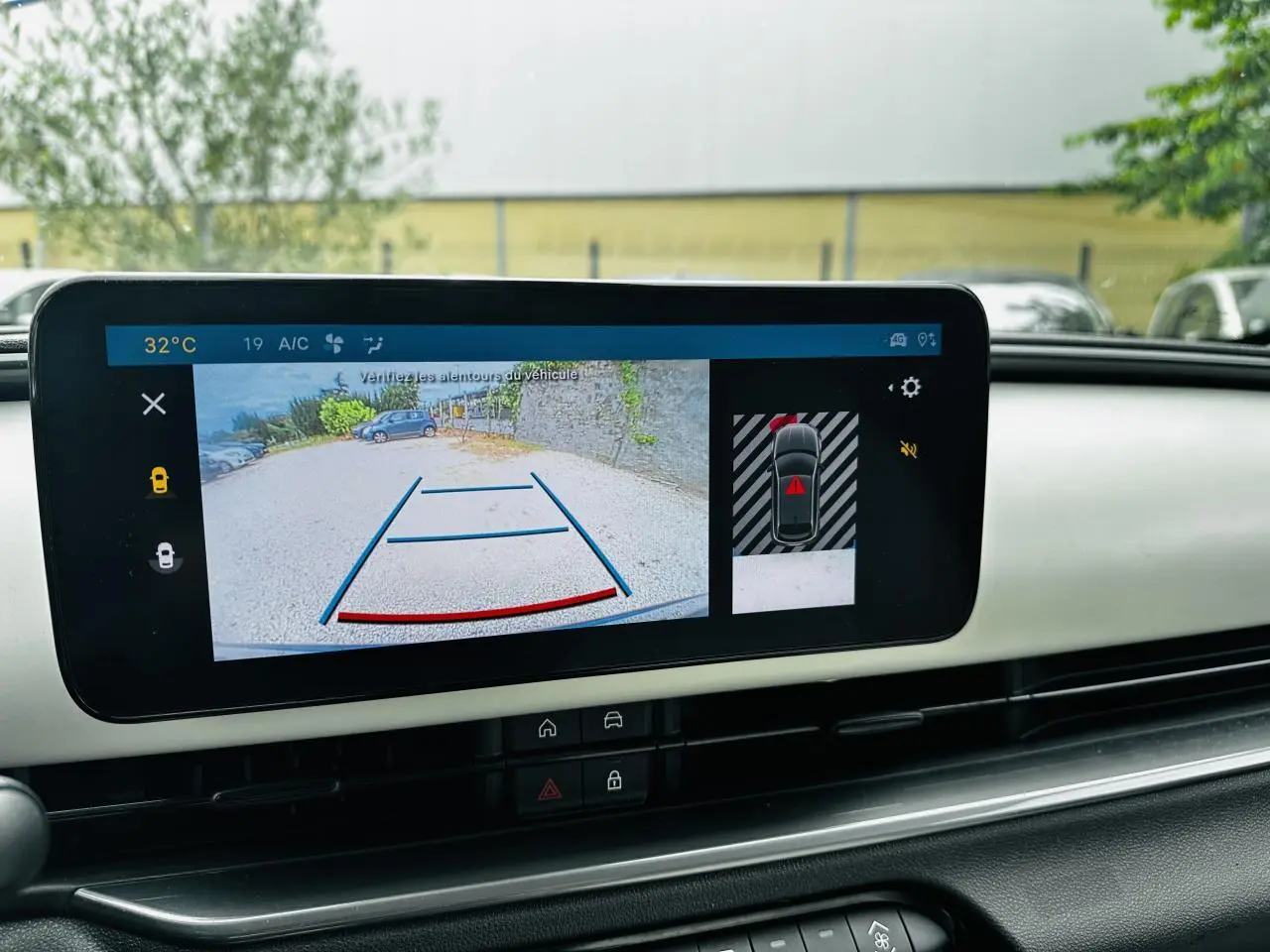 Écran central affichant la caméra de recul et l’aide au stationnement dans l’habitacle ivoire du Fiat 600 bleu clair.