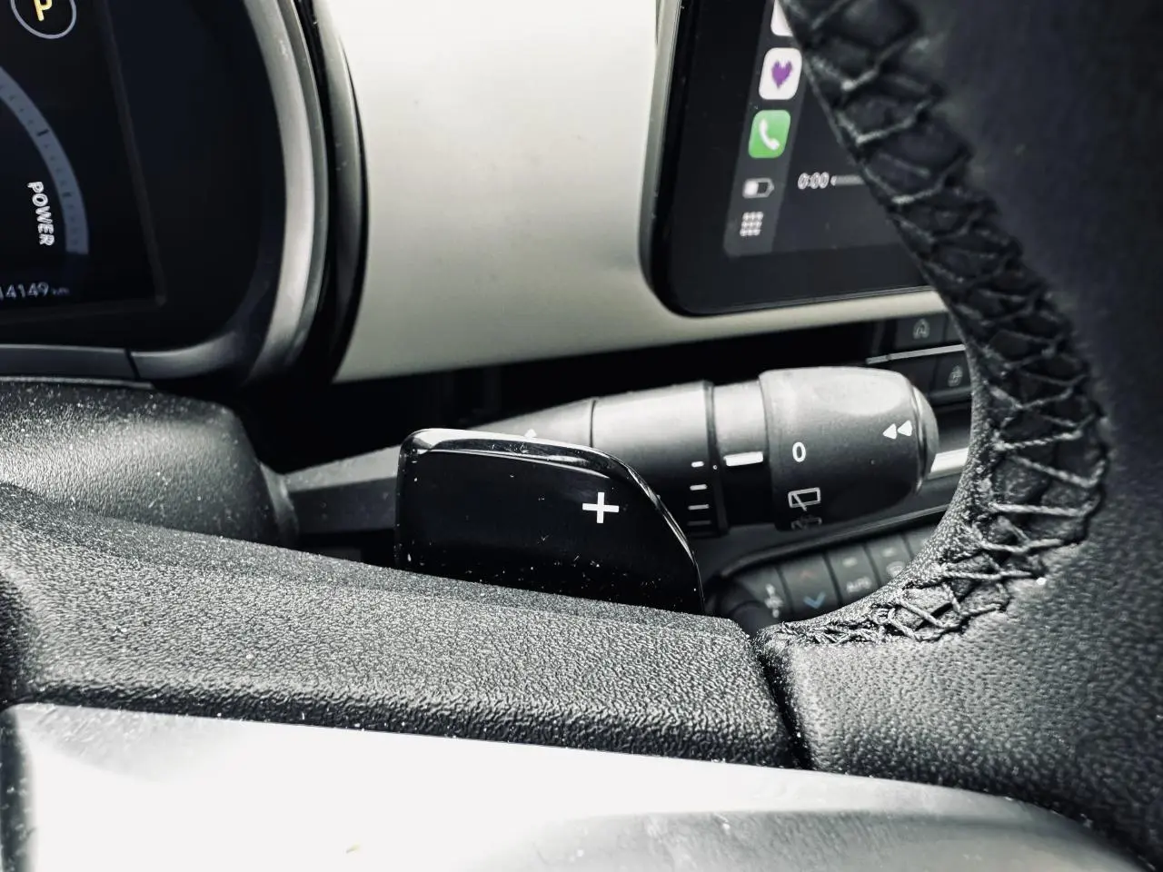 Gros plan sur la palette de changement de rapports côté droit du volant de la Fiat 600 La Prima bleu clair, tableau de bord partiel visible.