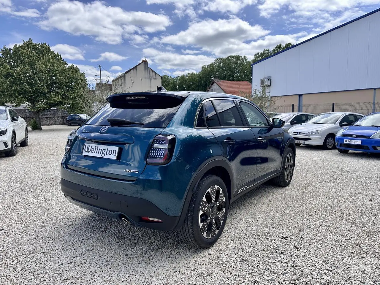 Vue 3/4 arrière droite de la FIAT 600 1.2 Hybrid bleu clair avec feux arrière LED et jantes noires distinctives.