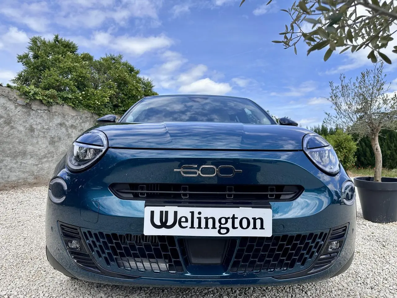 Vue avant rapprochée du FIAT 600 bleu clair 2024 avec logo 600 centré et phares ronds LED distinctifs.