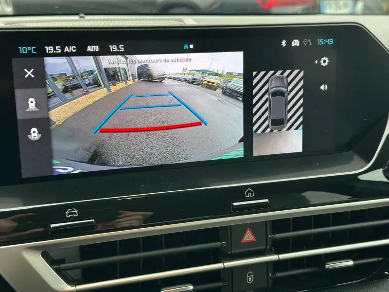 Écran multimédia montrant la caméra de recul du Citroën C4 X gris Mercury, avec guidage de trajectoire en bleu et rouge.