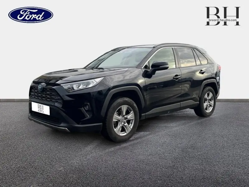 Toyota RAV4 2.5 Hybride noir métallisé vu en 3/4 avant droit, avec jantes alu et calandre noire distinctive.