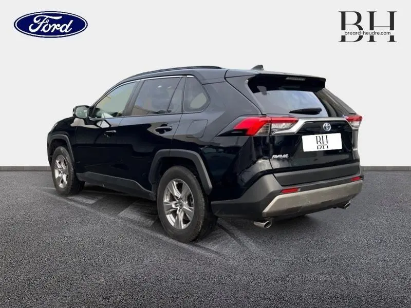 Toyota RAV4 noir métallisé vu en 3/4 arrière droit, avec feux LED et jantes alliage visibles.