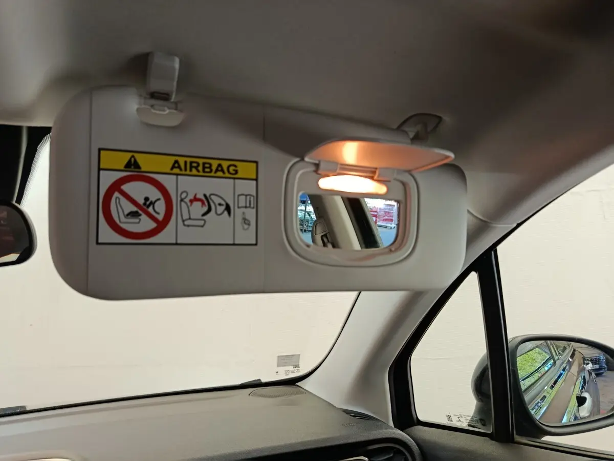 Détail intérieur du pare-soleil côté conducteur avec miroir éclairé dans une Fiat 500X blanche de 2020.