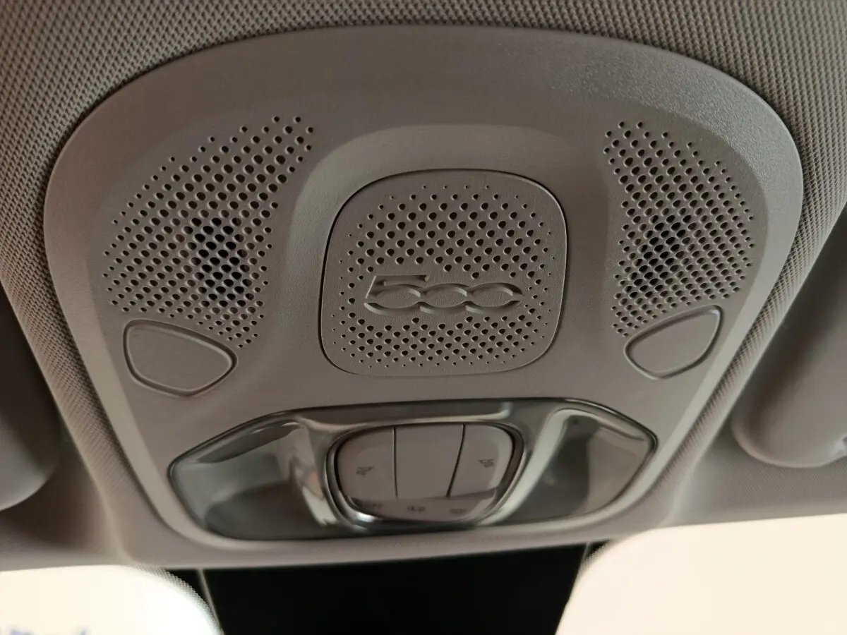 Plafonnier intérieur gris avec logo 500 et commandes d'éclairage, vue en contre-plongée dans une Fiat 500X blanche.
