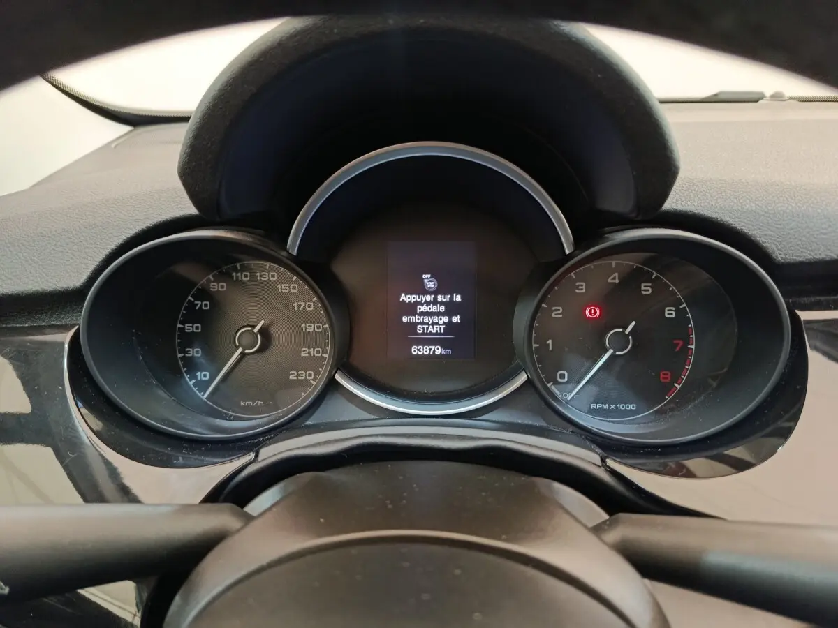 Vue rapprochée du tableau de bord noir de la Fiat 500X 2020, affichant le compteur et l'écran central digital.